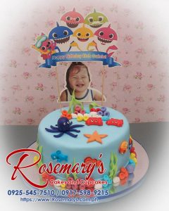 Delicious 1 layer Baby Shark themed cake in vibrant blue, featuring a cheerful shark family. Order from Rosemary's Cakes: 0917-598-9215.