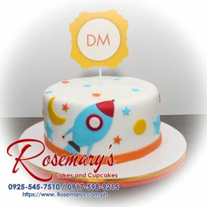 Delicious one-layer blue and white cake decorated with a fondant rocket soaring through space. Order your themed cakes from Rosemary's Cakes, call 0925-545-7510.