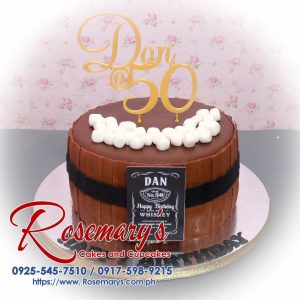 Delicious 1 layer Jack Daniels themed cake by Rosemary's Cakes featuring a 3D printed barrel, gold accents, and rich brown frosting. Contact: 0917-598-9215.