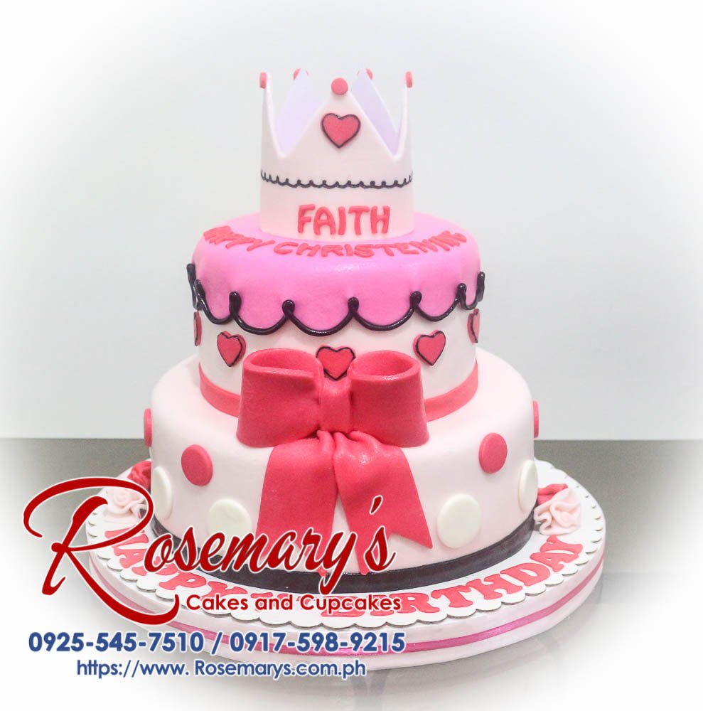 Delicious two-tier pink cake adorned with a delicate crown and ribbon. Order your custom cakes from Rosemary's Cakes! Call 0917-598-9215.