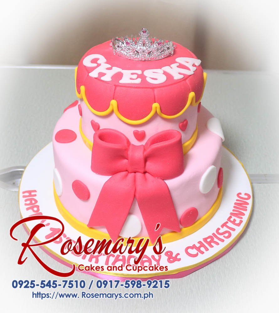 Elegant two-tier pink cake adorned with a delicate crown and satin ribbon. Perfect for birthdays and celebrations. Rosemary's Cakes - 0917-598-9215.