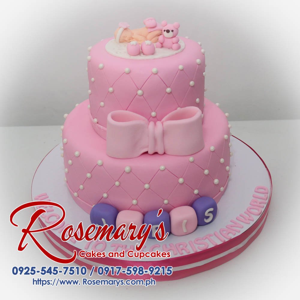 Delicious two-tier pink christening cake with fondant baby and delicate ribbon. Order yours from Rosemary's Cakes! 0917-598-9215