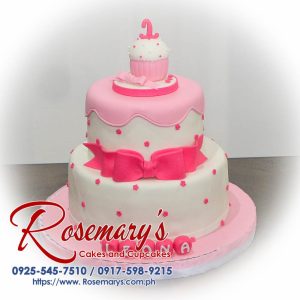 Two-layer pink cake adorned with a white ribbon. Delicious and perfect for birthdays! Order yours from Rosemary's Cakes: 0917-598-9215.