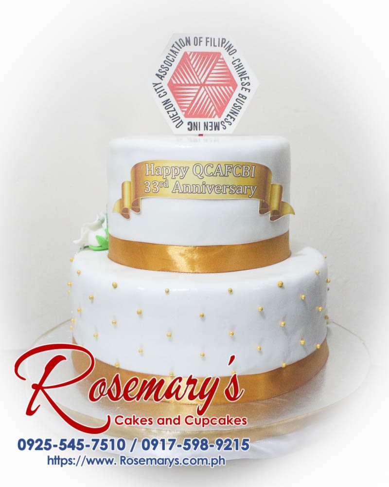 2 Layer Cake for QCAFCBI’s 33 Anniversary Stunning 2 layer cake in elegant gold and white, perfect for celebrations. Order from Rosemary's Cakes at 0925-545-7510.