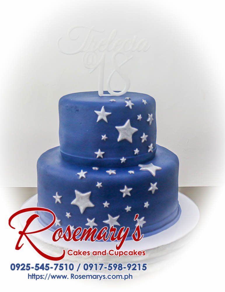 Two-tier blue cake with silver stars and a 3D printed topper. Custom cakes by Rosemary's Cakes: 0925-545-7510.