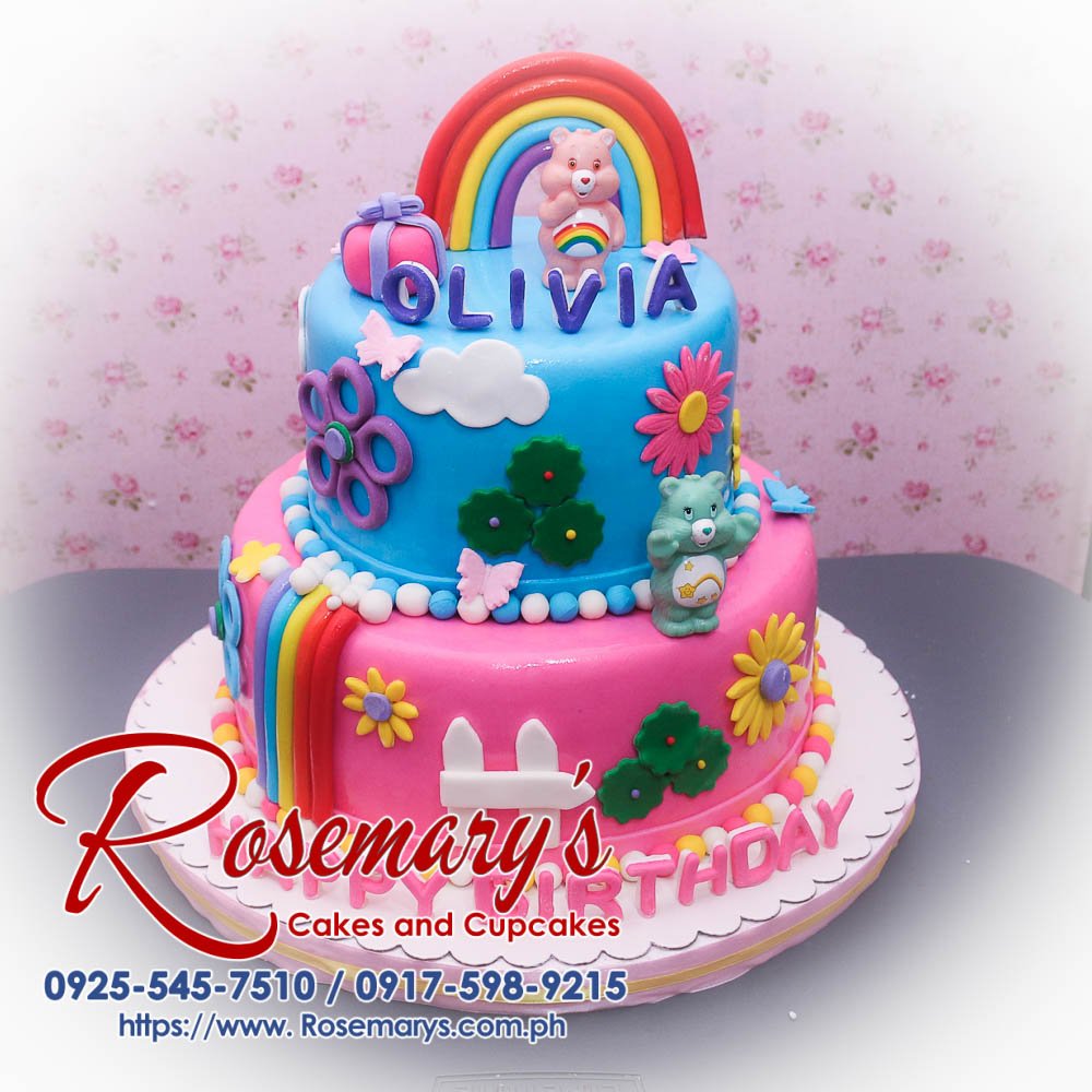 Delicious 2 layer Care Bears cake by Rosemary's Cakes, featuring blue and pink design with rainbow accents. Contact: 0925-545-7510.