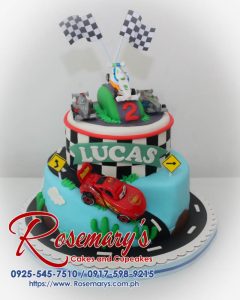 Delicious two-tier blue cake decorated with toy cars. Order your custom cake from Rosemary's Cakes! 0925-545-7510