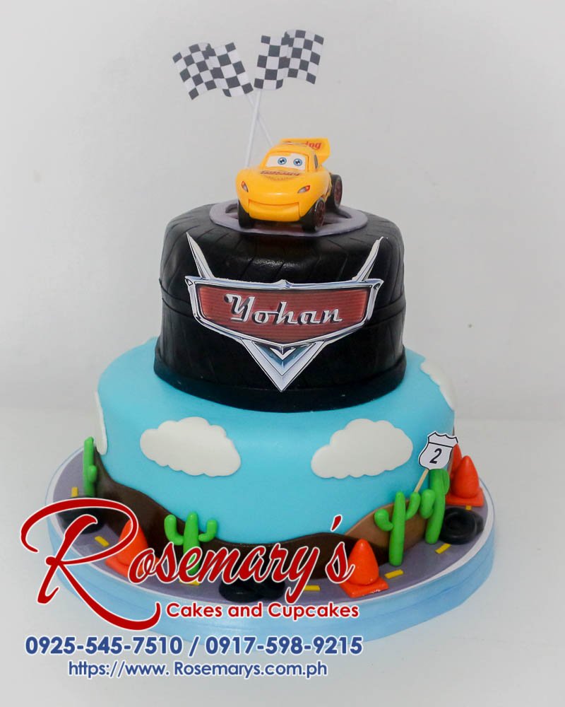 Two-tier car-themed cake featuring a fondant Lightning McQueen. Delicious and perfect for any celebration! Order yours from Rosemary's Cakes: 0925-545-7510.