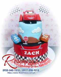 Delicious two-tier blue and red car-themed cake with Lightning McQueen details. Custom cakes by Rosemary's Cakes: 0917-598-9215.