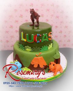Delicious 2 layer dinosaur themed cake from Rosemary's Cakes, featuring vibrant green frosting and fun dinosaur decorations. Contact 0925-545-7510.