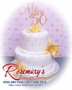 Elegant 2 layer gold and white cake by Rosemary's Cakes, featuring intricate 3D printed designs. Contact: 0925-545-7510.