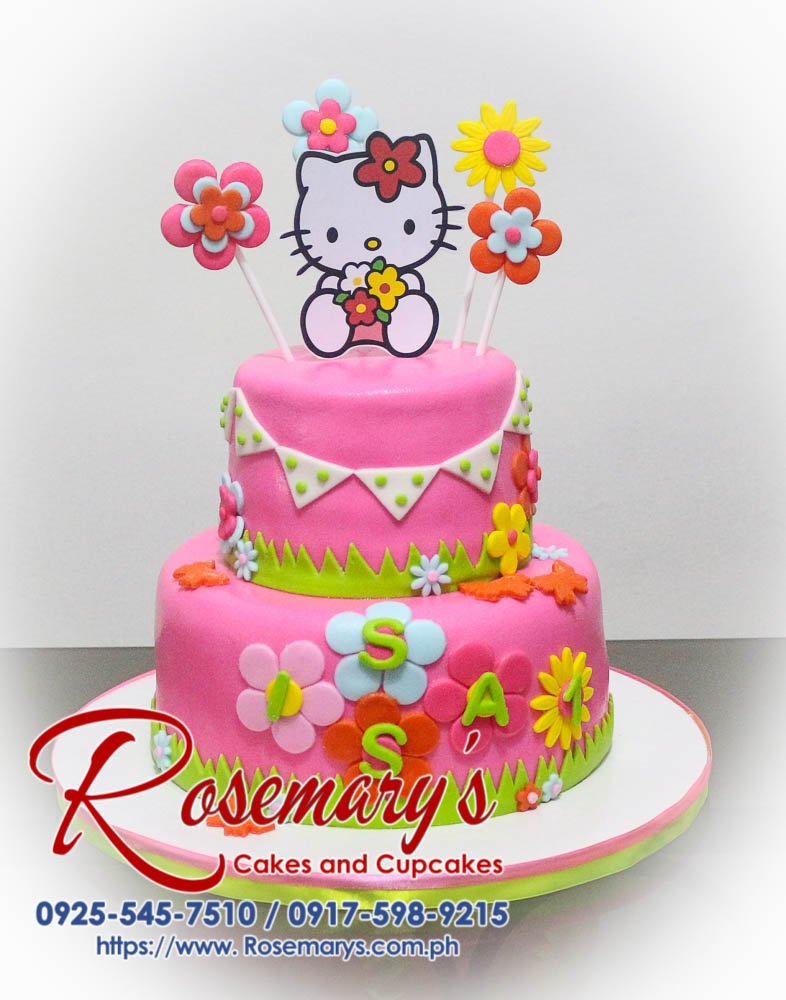 Delicious two-tier pink Hello Kitty cake adorned with delicate flowers. Perfect for birthdays! Order yours from Rosemary's Cakes: 0925-545-7510.