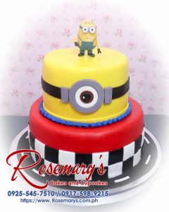 Delicious 2-layer Minions themed cake in vibrant yellow and black, featuring playful red accents. Order from Rosemary's Cakes at 0917-598-9215.
