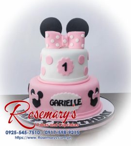 Two-tier pink Minnie Mouse cake with black polka dots and a red bow. By Rosemary's Cakes: 0917-598-9215.