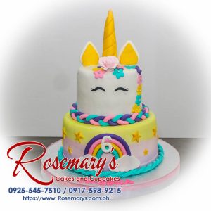 Two-layer pastel rainbow cake adorned with a golden unicorn horn and ears. Perfect for birthdays and celebrations! By Rosemary's Cakes. Call 0925-545-7510.