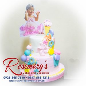 Two-layer pastel Candyland themed cake with colorful candies and frosting details. Order your custom cake from Rosemary's Cakes! Call 0917-598-9215.