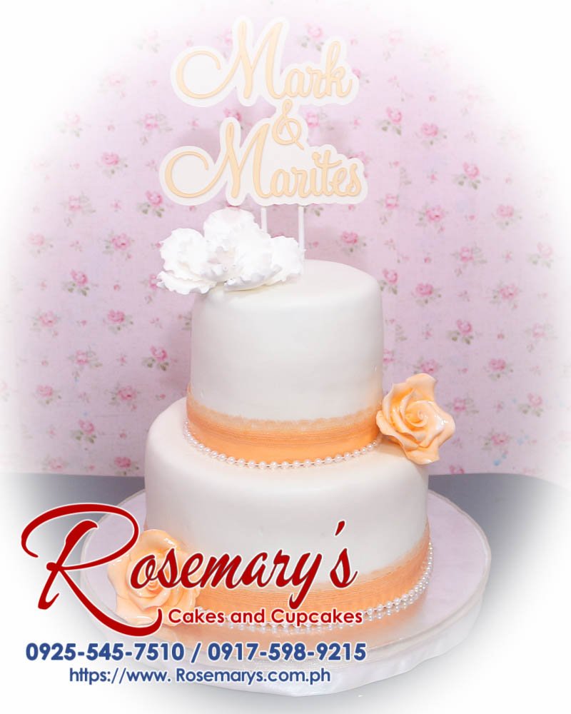 Delicious 2-layer peach and white wedding cake, beautifully decorated for a themed celebration. Order from Rosemary's Cakes at 0925-545-7510.