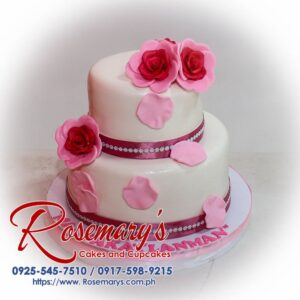 Two-tier pink wedding cake adorned with delicate sugar roses. Perfect for a romantic celebration! Rosemary's Cakes - 0917-598-9215