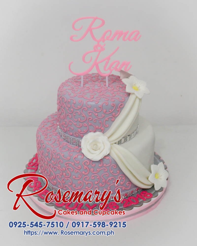 Delicious two-layer pink and silver wedding cake featuring a unique 3D printed topper. Order your custom cake from Rosemary's Cakes: 0925-545-7510
