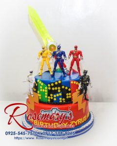 Two-tier Power Rangers cake with vibrant blue and red fondant accents. Delicious birthday treat from Rosemary's Cakes. Call 0925-545-7510.