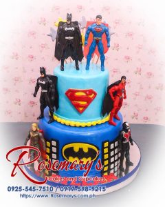 Delicious 2 layer Superman and Batman themed cake in vibrant blue, perfect for superhero fans. Order from Rosemary's Cakes: 0917-598-9215.