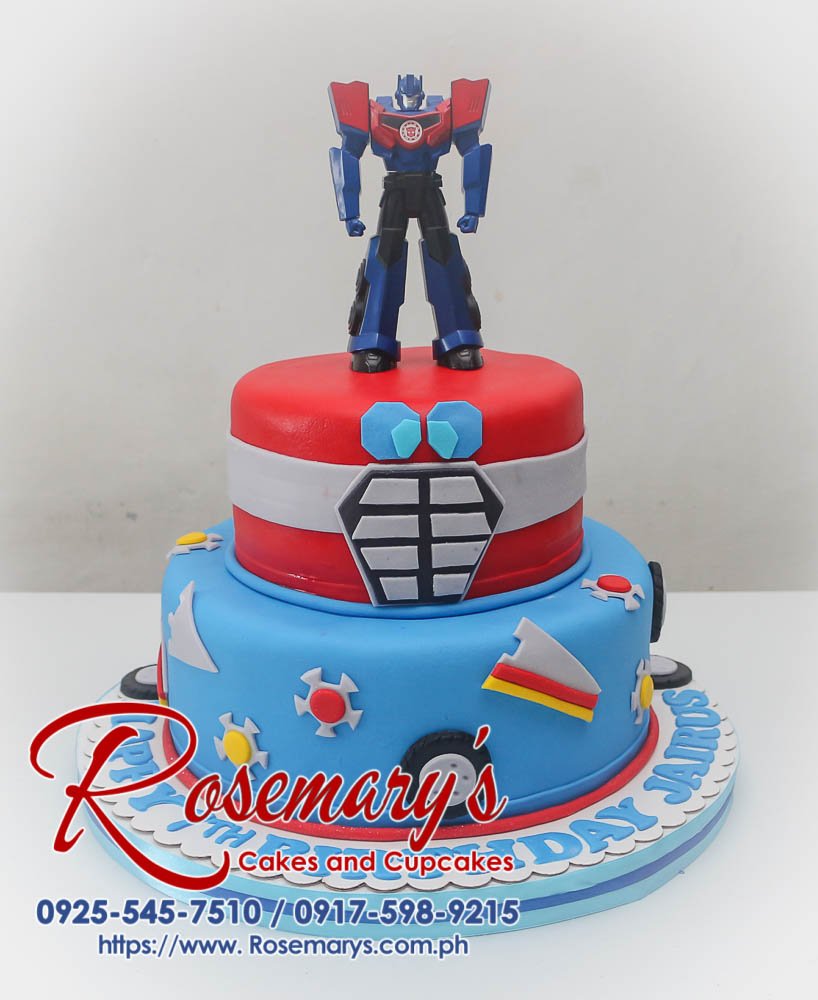 Two-tier blue and red Transformers themed birthday cake with fondant details. Custom cakes by Rosemary's Cakes: 0925-545-7510