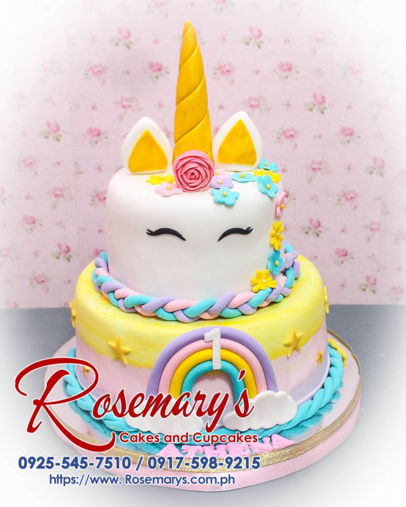 Delicious 2-layer unicorn cake with pastel rainbow colors, gold accents, and whimsical design. Order from Rosemary's Cakes at 0925-545-7510.