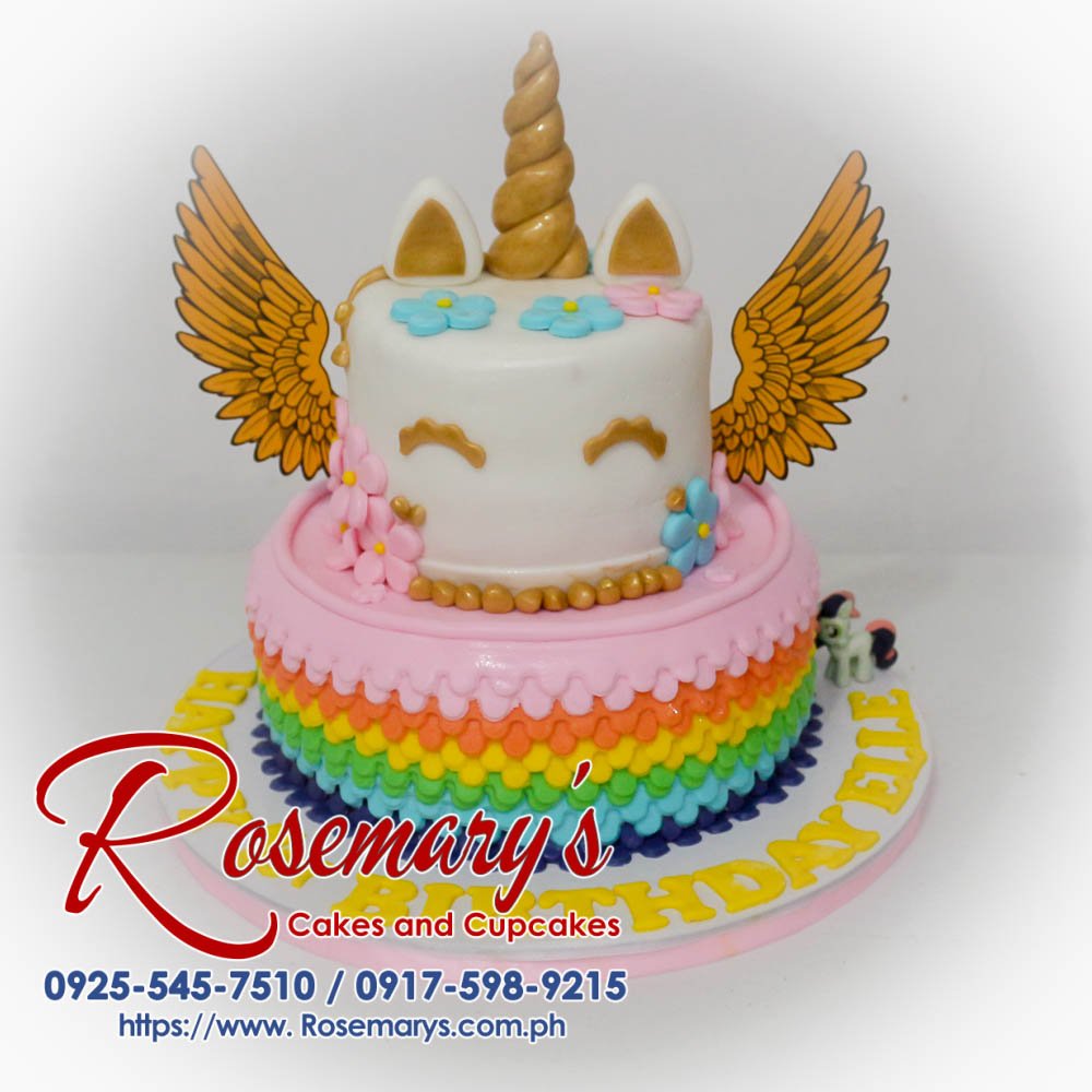 Two-tier rainbow cake with unicorn horn and edible gold accents. Delicious celebration treat from Rosemary's Cakes! Call 0925-545-7510