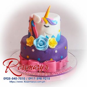 Delicious two-layer pink and purple unicorn themed cake adorned with a ribbon. Order your custom cake from Rosemary's Cakes: 0917-598-9215.