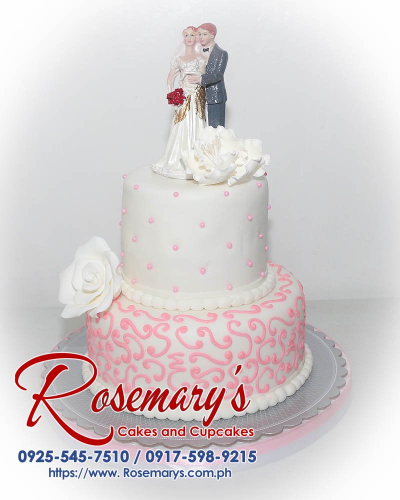 Two-tier white and pink wedding cake adorned with delicate pink roses. Delicious and elegant for your special day. Rosemary's Cakes | 0917-598-9215