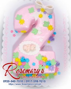 Delicious pink number cake with flowers and ribbon, perfect for celebrations. From Rosemary's Cakes. Contact: 0917-598-9215.
