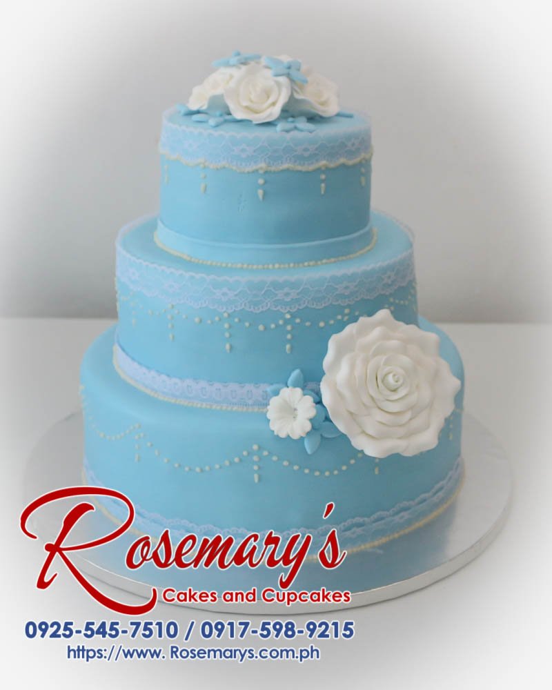 Elegant three-tier blue wedding cake with smooth buttercream frosting. Order your dream cake from Rosemary's Cakes: 0925-545-7510