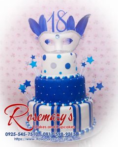 3 layer masquerade themed cake with blue frosting, 3D printed mask topper, and star accents. Order from Rosemary's Cakes: 0917-598-9215.