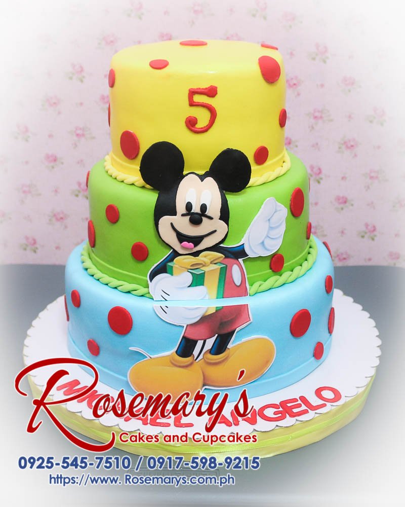3 Layer Mickey Mouse Themed Cake For Michael Angelo Delicious 3 layer Mickey Mouse themed cake in blue, green, and yellow. Perfect for any celebration! Rosemary's Cakes, 0917-598-9215.