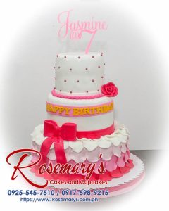 Three-layer pink and white themed cake adorned with a ribbon, crafted by Rosemary's Cakes. Contact 0917-598-9215.
