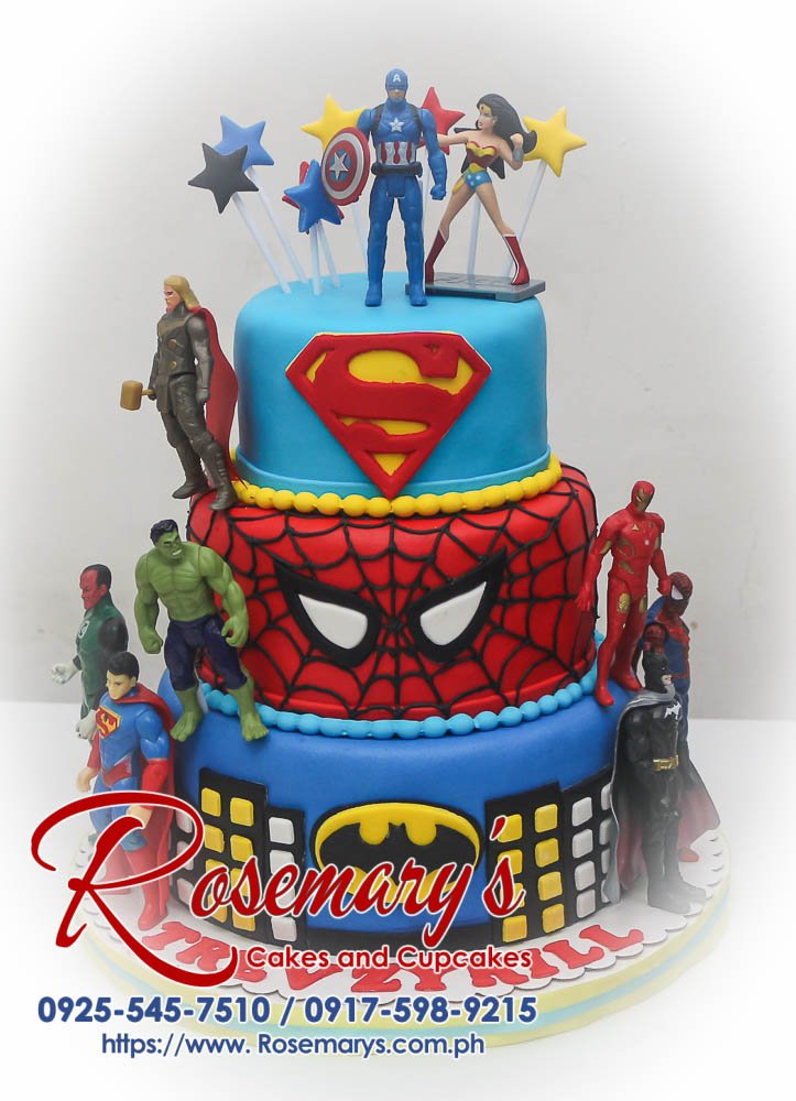 Three-tier superhero cake with blue, red, and yellow fondant. Featuring Batman, Superman, and Spiderman logos. Order custom cakes from Rosemary's Cakes: 0917-598-9215.