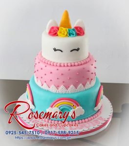 Three-tier pink cake adorned with rainbows and a fondant unicorn. Perfect for whimsical celebrations! By Rosemary's Cakes, 0925-545-7510.