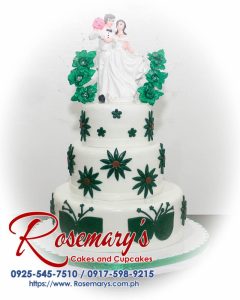 Stunning 3 layer white and green wedding cake by Rosemary's Cakes, featuring elegant floral accents. Call 0917-598-9215.