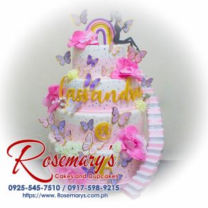 4-layer pink themed cake adorned with 3D printed butterflies, perfect for special occasions. From Rosemary's Cakes, call 0925-545-7510.