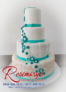 Elegant 4-layer white wedding cake with teal accents. For stunning custom cakes, contact Rosemary's Cakes at 0917-598-9215.