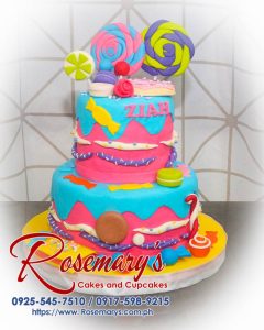 Delicious 2 layer Candyland themed cake with pink frosting, lollipops, and vibrant candy decorations from Rosemary's Cakes. Contact: 0917-598-9215.
