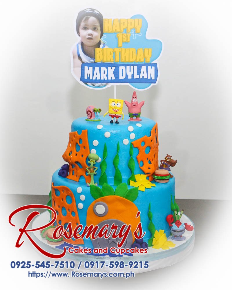 Delicious 2 layer Spongebob themed cake in vibrant blue, perfect for any celebration. From Rosemary's Cakes, call 0925-545-7510.