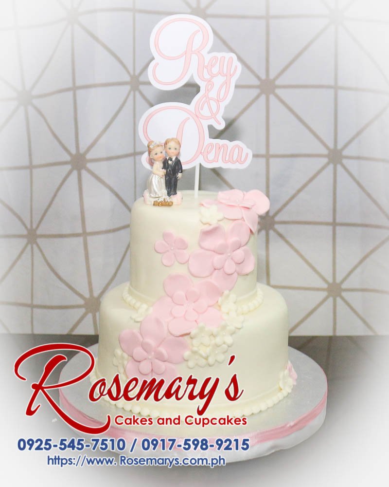 Elegant 2-layer white and pink wedding cake with delicate floral accents. Perfect for special celebrations. Rosemary's Cakes, 0917-598-9215.