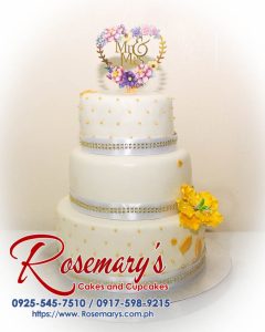 Elegant 3-layer white and gold wedding cake by Rosemary's Cakes, perfect for any celebration. Contact: 0917-598-9215.